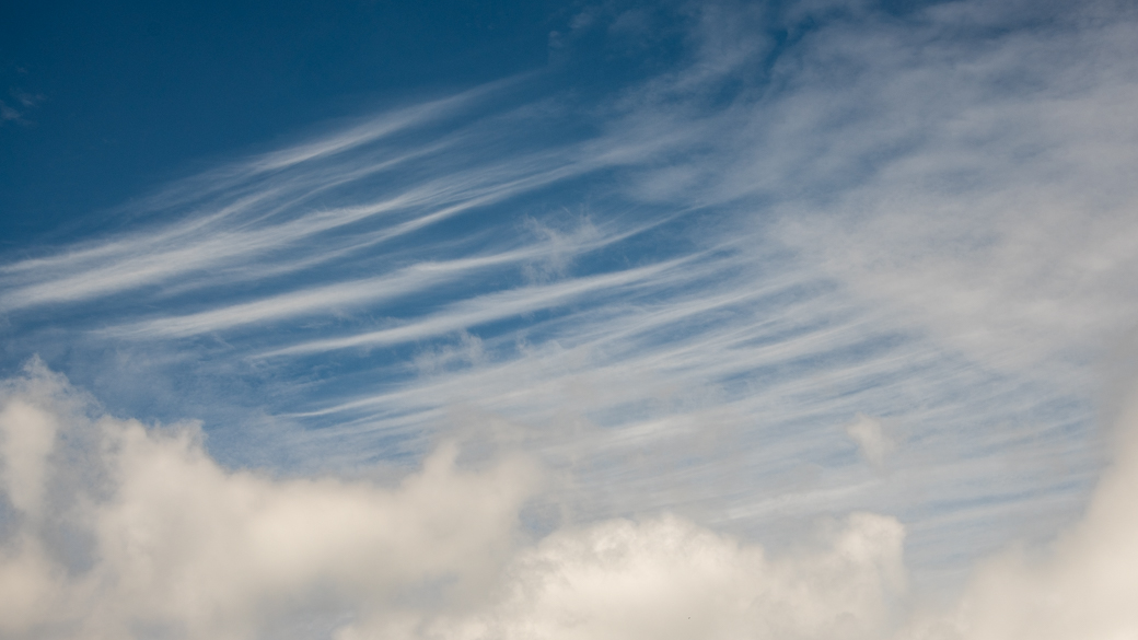 A photograph of cirrus fibratus clouds (Ci fib) above a stratocumulus layer